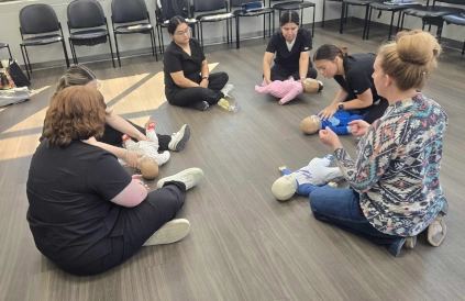  Group of Odessa Dental Assistant School students and instructor seated in a circle learning CPR basics 
